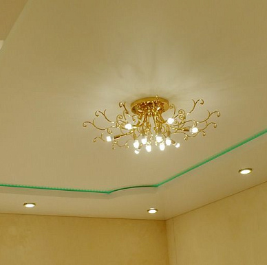 Белый двухуровневый натяжной потолок с подсветкой и люстрой в зале